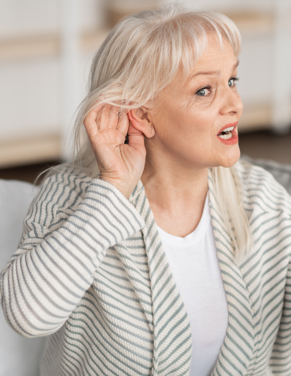 Ältere Dame hält sich eine Hand ans Ohr als Geste, dass Sie nicht hören kann.